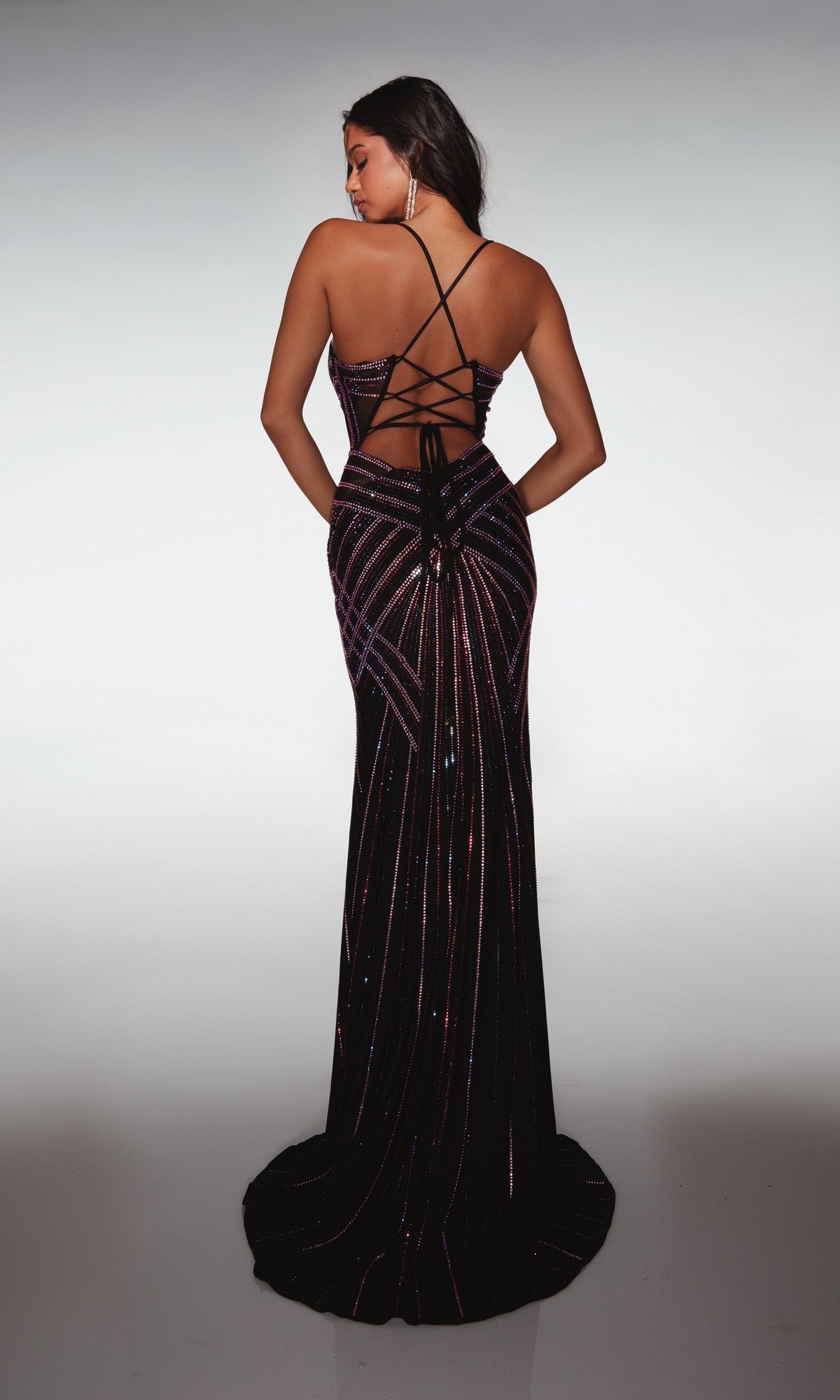 A woman faces away, wearing the Alyce 62100 long prom dress with a sleeveless design, lace-up back, and geometric sequin patterns.